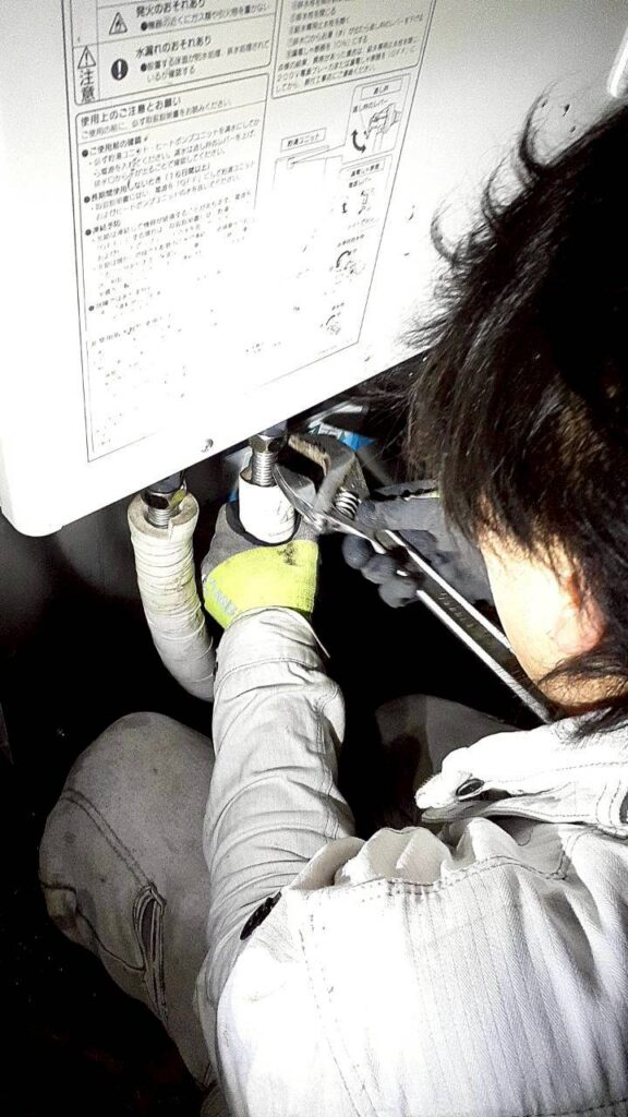 電気工事士がエコキュートの配管を点検・修理している様子